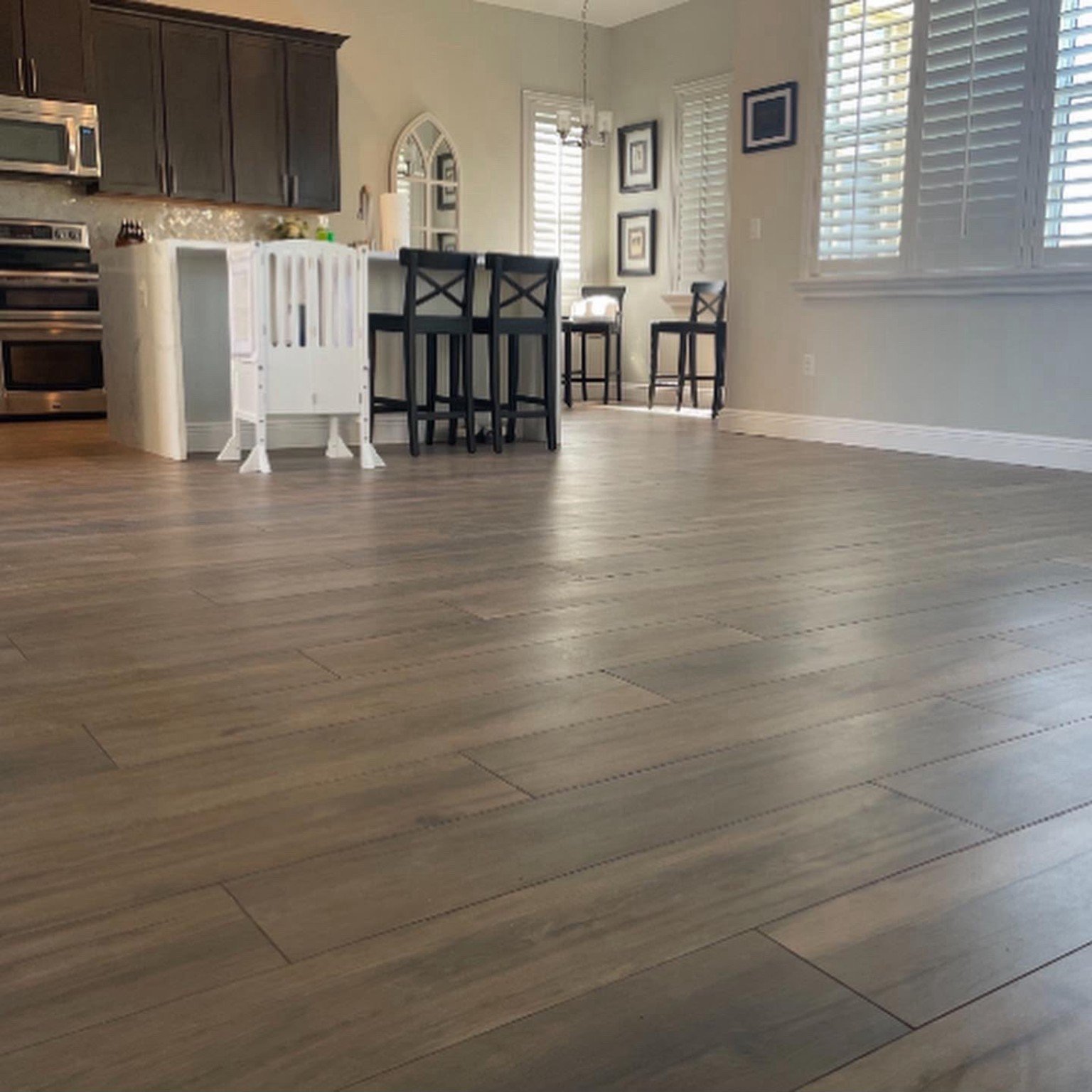 Warm wood-look flooring connecting the kitchen and dining area.
