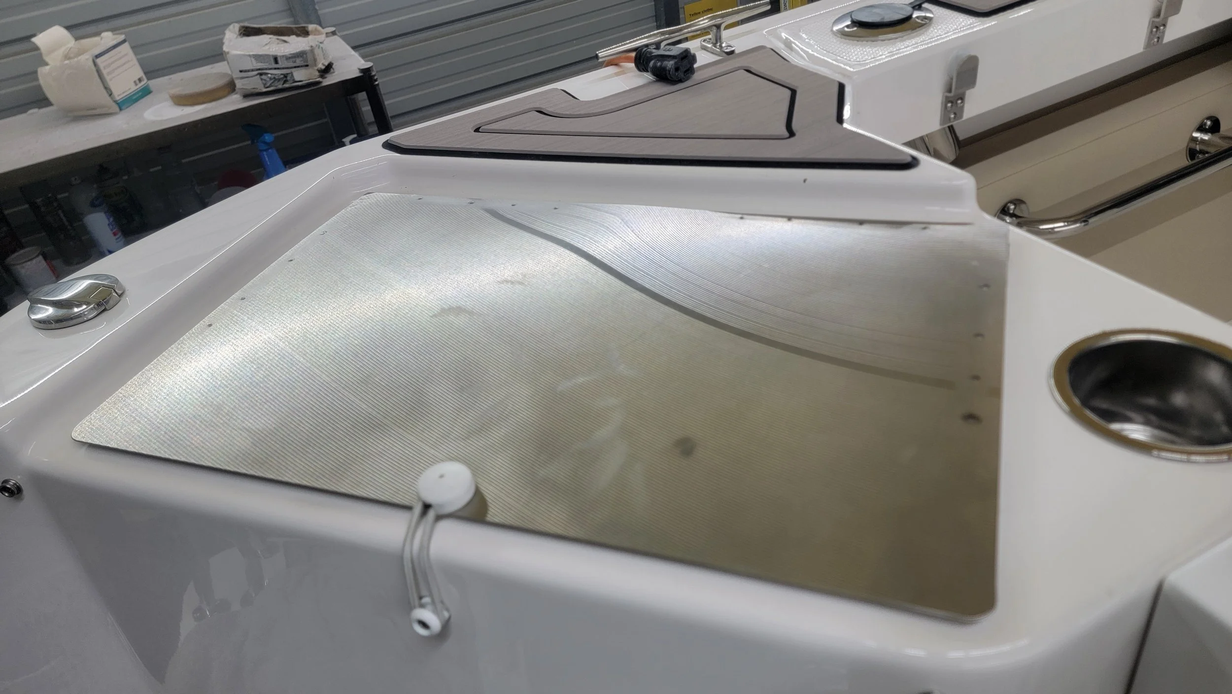 Close-up of a white hydrotherapy bathtub with textured floor, chrome fixtures, wooden bath tray, and drain.