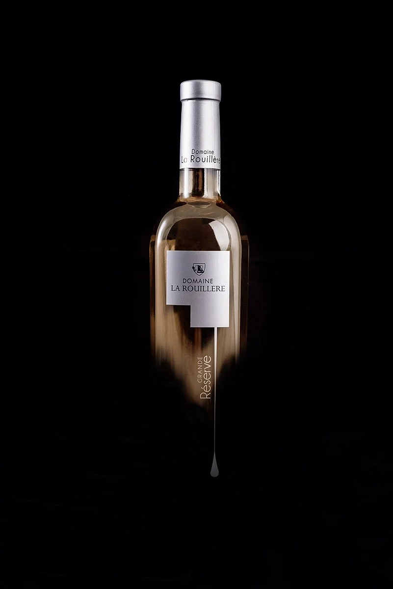 Bouteille de vin blanc de la marque Domaine La Rouillère, variété Grande Réserve, contre un fond noir