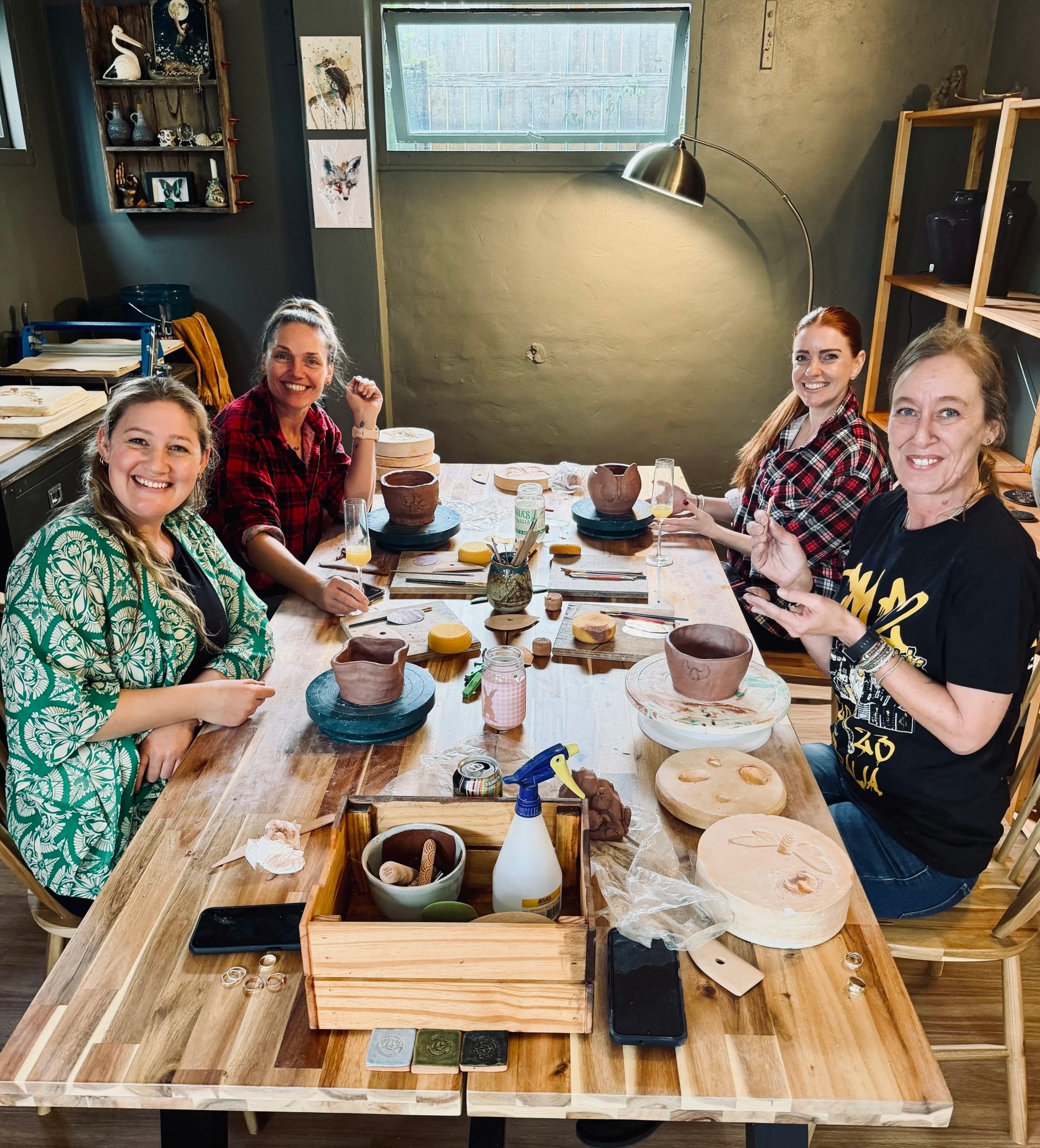 Four women sitting at a wooden table in Casey Anne St John's home studio for private workshop with Casey