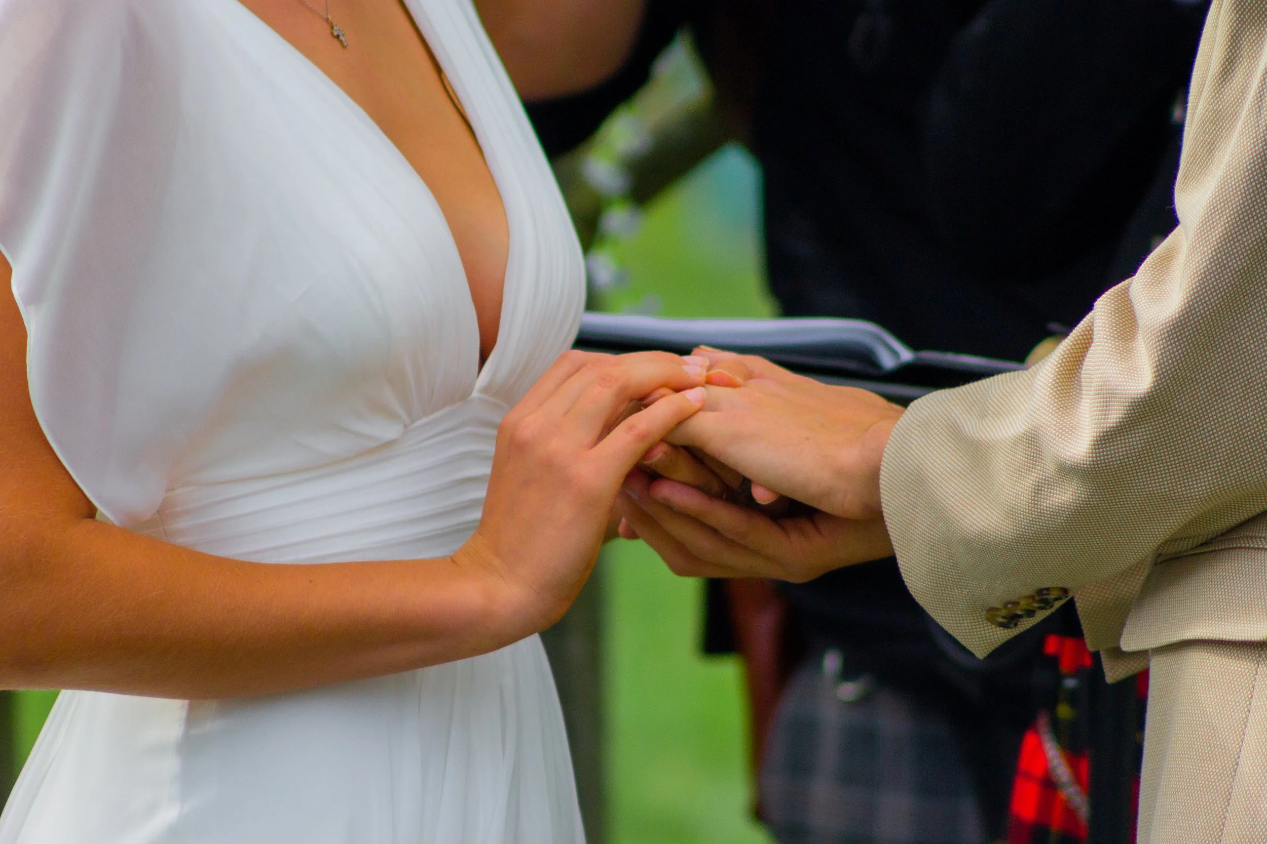 A bride and groom exchange wedding vows, holding hands during the ceremony.