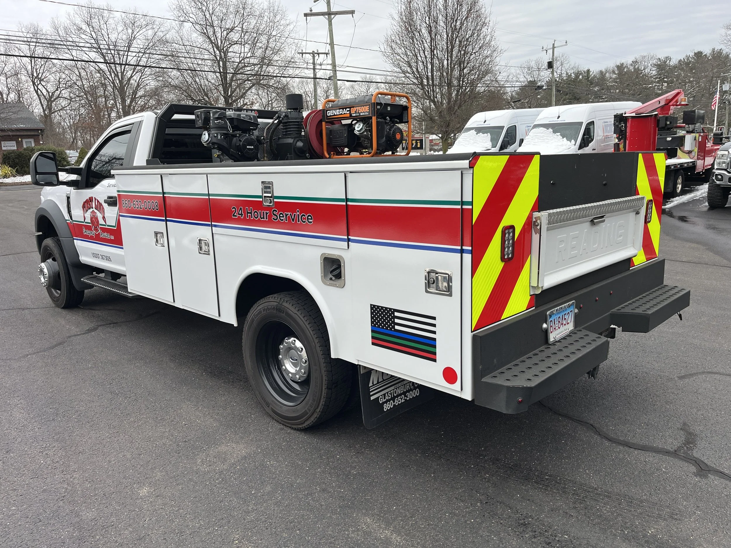 Custom logo duplication and applied to utility truck with reflective stripes, flags, and rear chevron for First Line Emergency Services