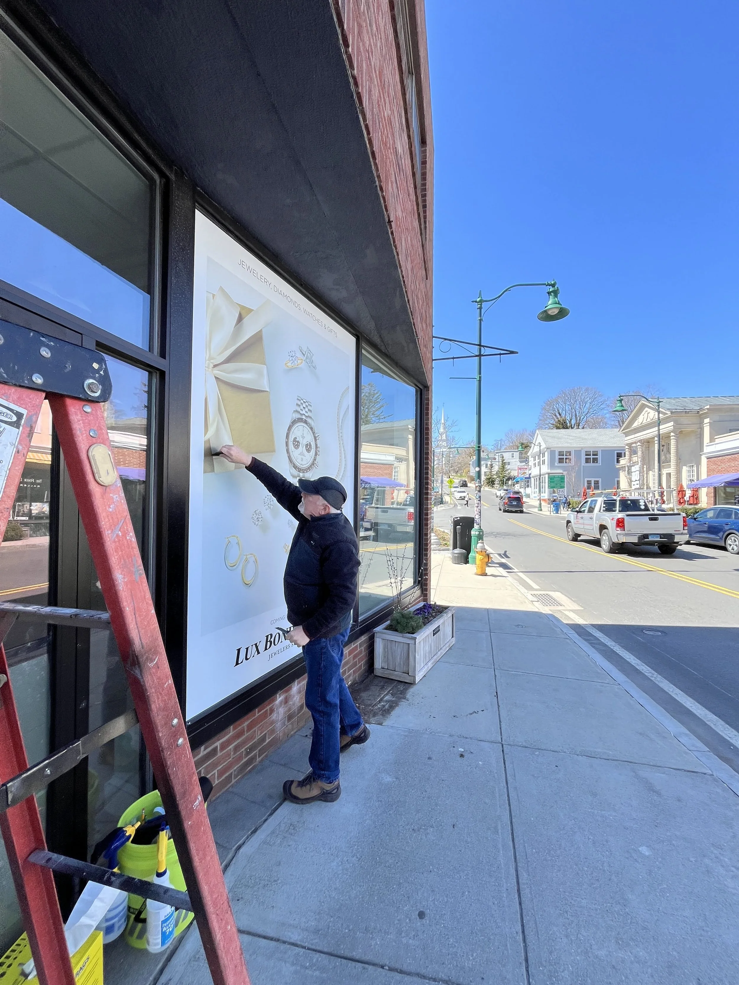 Chris installing window graphics on location in Mystic, CT