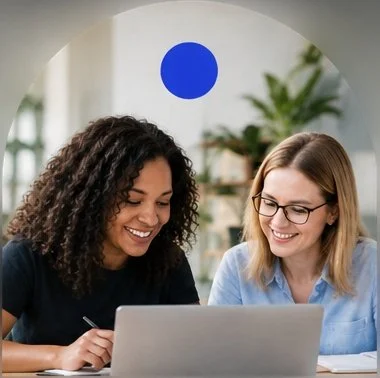 two women colleagues looking at laptop