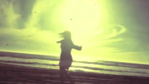 Silhouette of a person running along a beach with a bright sun or sunset in the background.