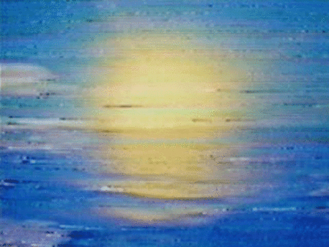 Sunset over the ocean with a yellow and orange sky and calm water reflecting the colors.