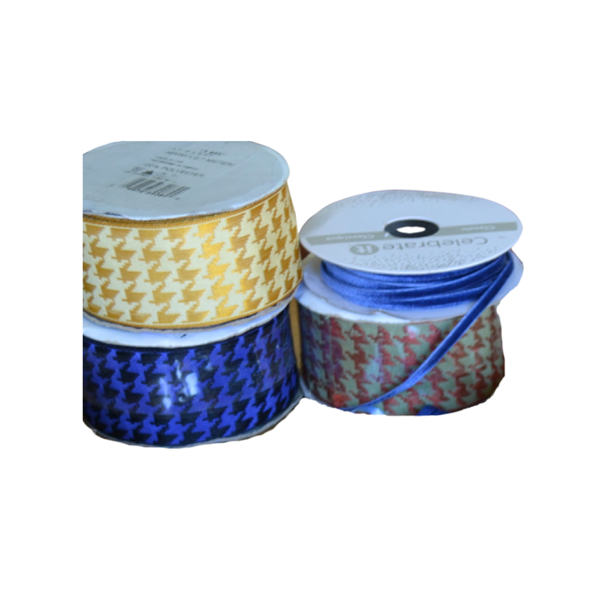 Close-up of spools of ribbon in yellow, blue, and red with houndstooth patterns and cardboard boxes of various colors in the background.