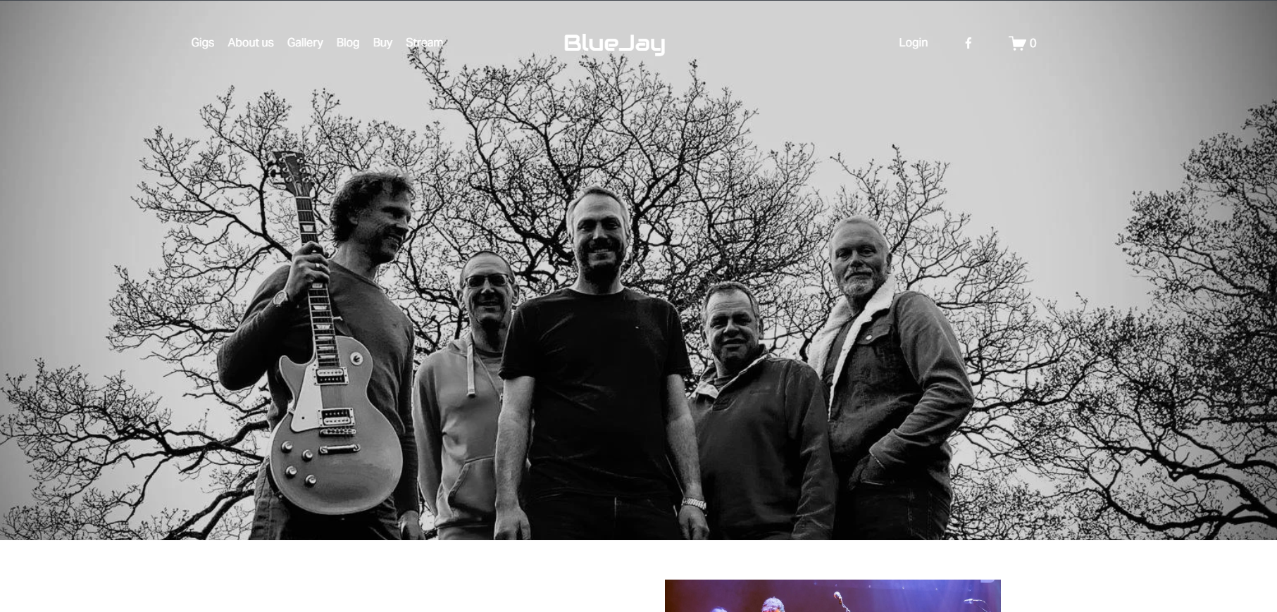 Black and white photo of five men outdoors standing in front of a tree with bare branches. One man holds an electric guitar. They are smiling and posing for the picture.