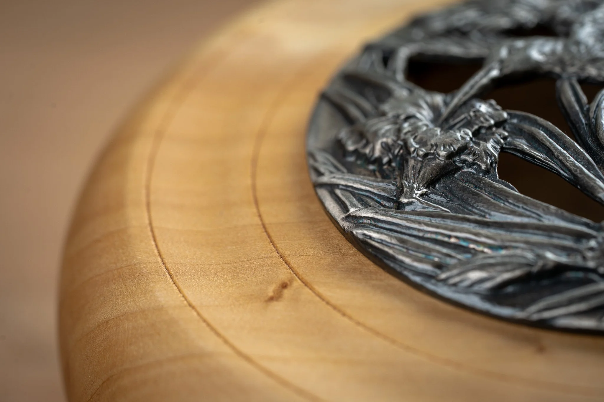 Close-up of a metallic eagle emblem on a wooden surface.