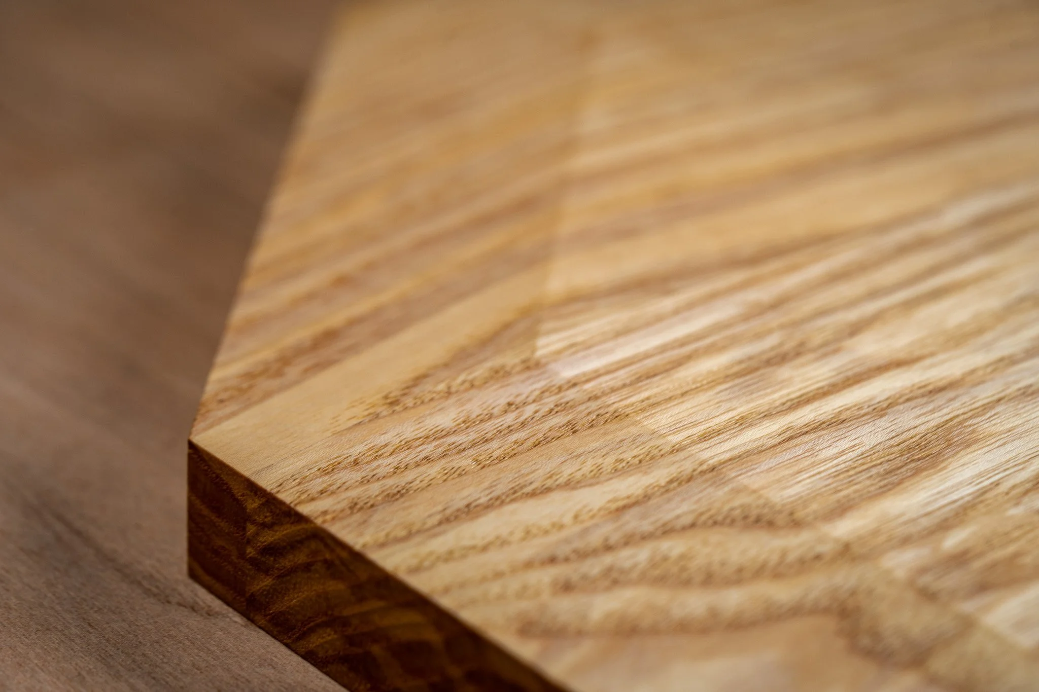 A close-up view of a wooden block with a natural wood grain pattern and a smooth surface.