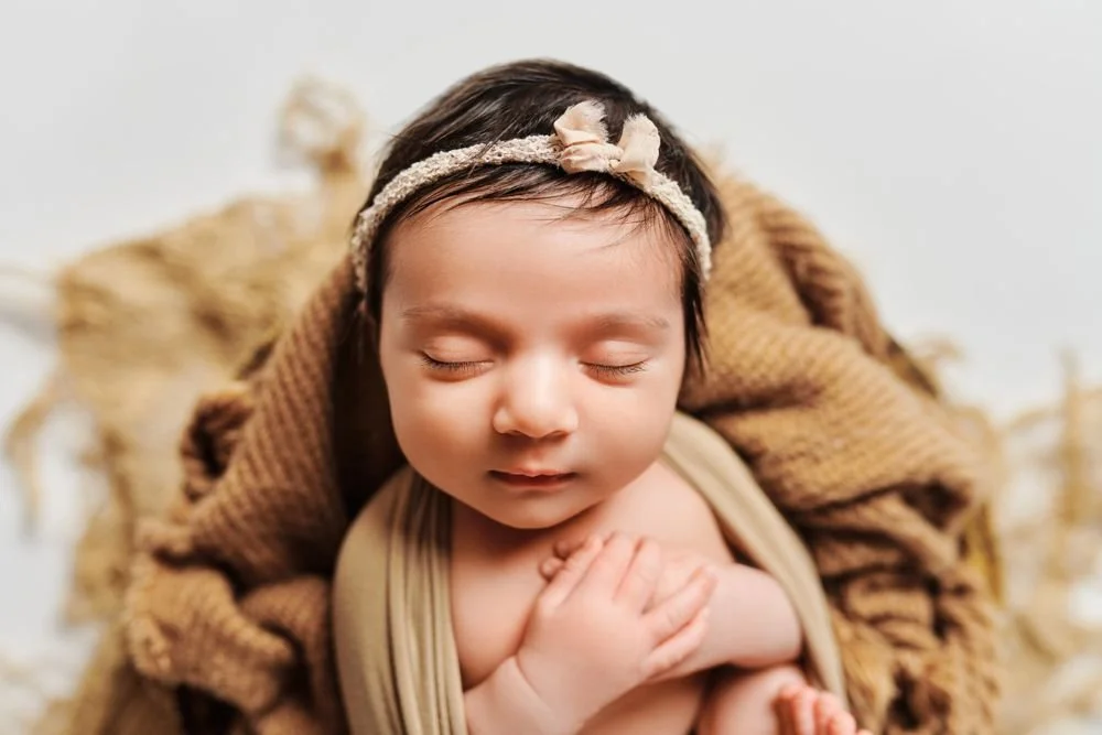 Newborn photography in Austin, Texas by Breeanna Rose Photography. Newborn close-up, brown wrap and headband.