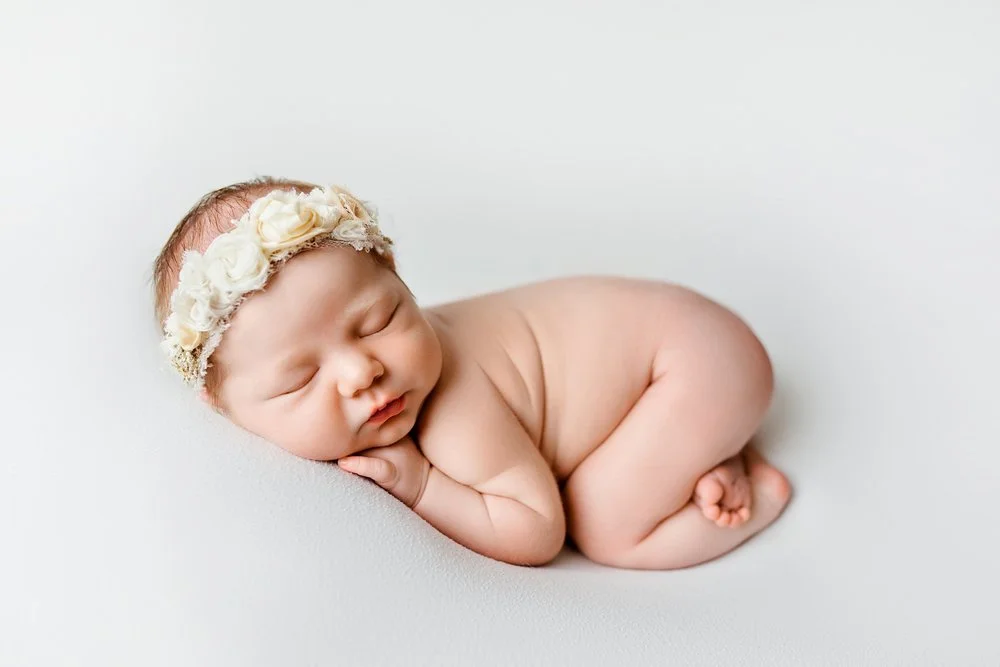 Newborn photography in Austin, Texas by Breeanna Rose Photography. Sleeping poses with floral headband.