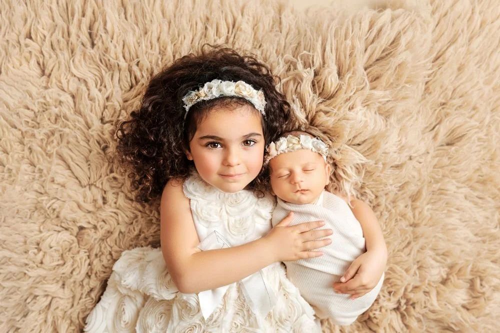 Newborn photography in Austin, Texas by Breeanna Rose Photography. Big sister lying with the baby.
