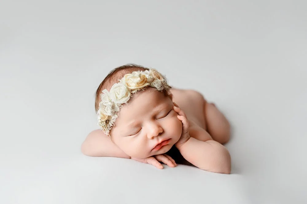 Newborn photography in Austin, Texas by Breeanna Rose Photography. Sleeping poses with floral headband.
