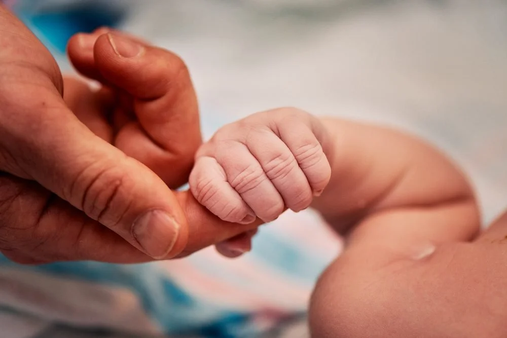 Birth photography in Austin, Texas by Breeanna Rose Photography. Tiny hand gripping a finger.