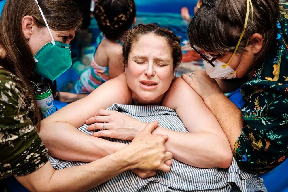 Birth photography in Austin, Texas by Breeanna Rose Photography. Partner embracing her from behind in the pool.