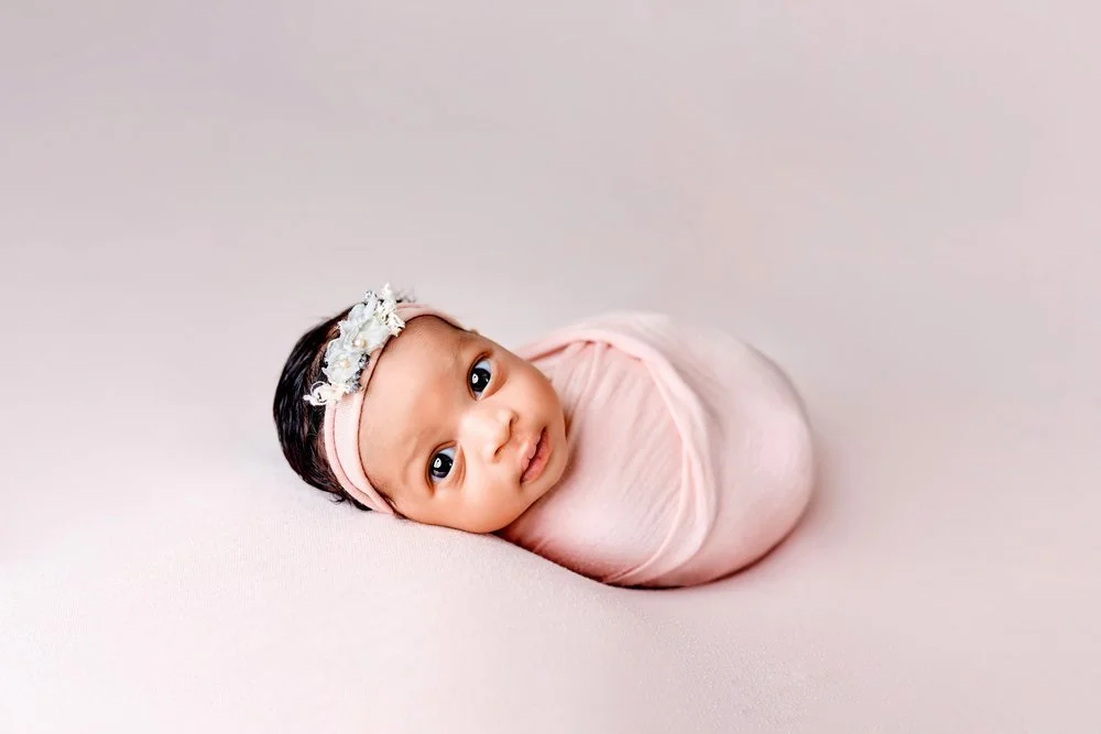 Newborn photography in Austin, Texas by Breeanna Rose Photography. Awake in pink swaddle.