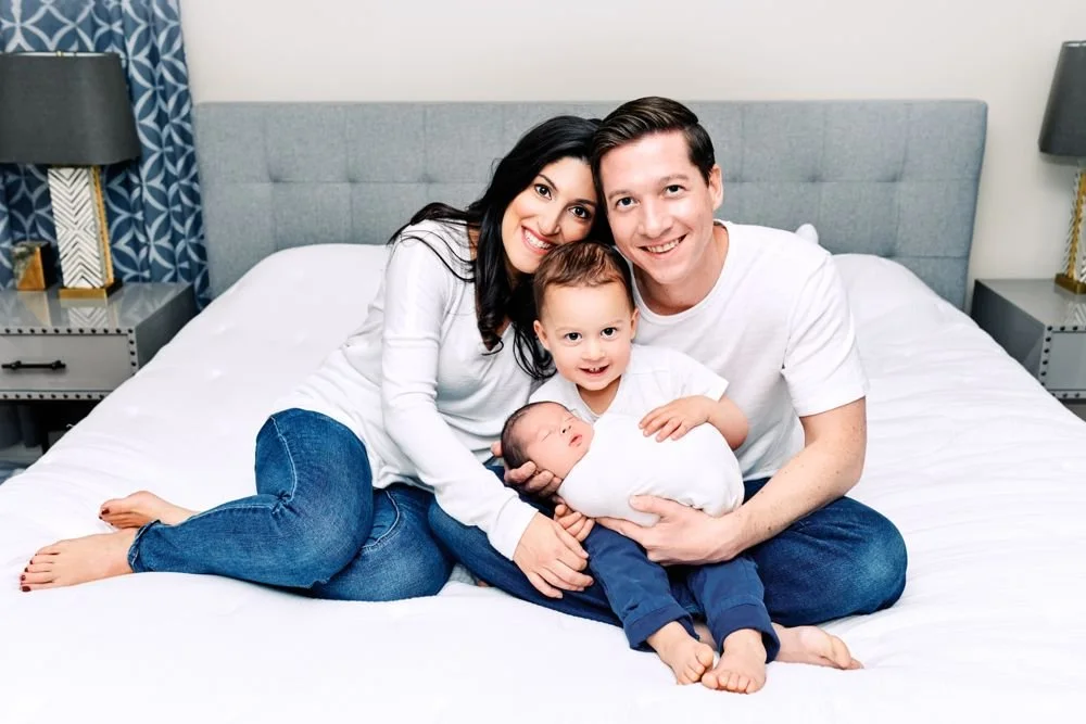Newborn photography in Austin, Texas by Breeanna Rose Photography. Family on the bed with their newborn.