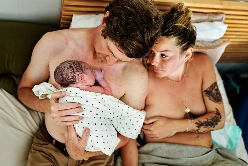 Birth photography in Austin, Texas by Breeanna Rose Photography. Couple cuddling baby, golden light.
