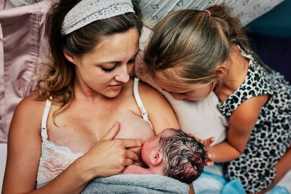 Birth photography in Austin, Texas by Breeanna Rose Photography. First nursing, daughter watching.