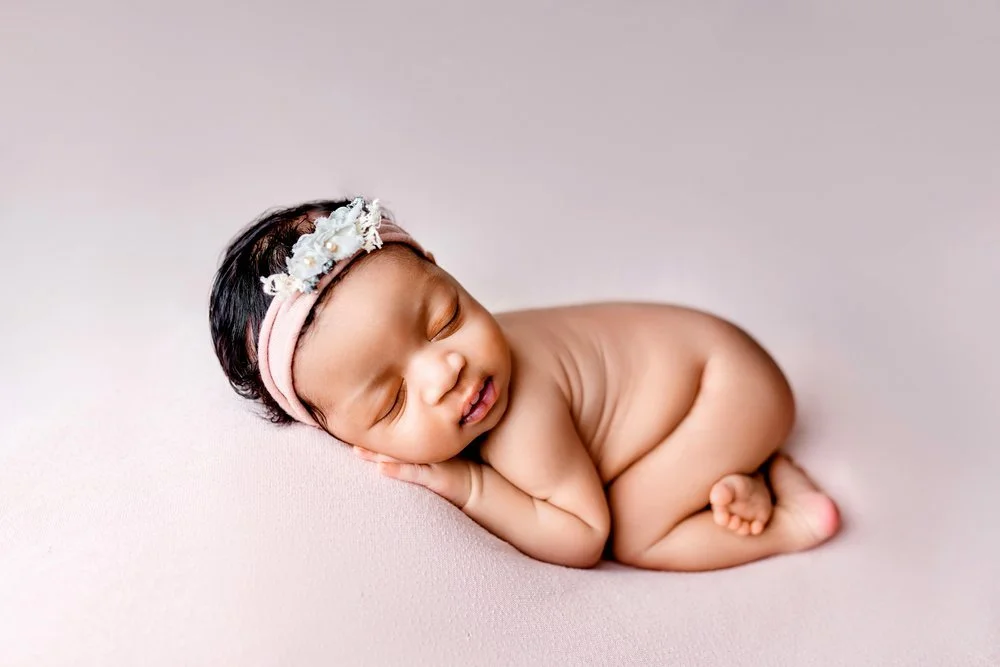 Newborn photography in Austin, Texas by Breeanna Rose Photography. Sleeping on pink backdrop.