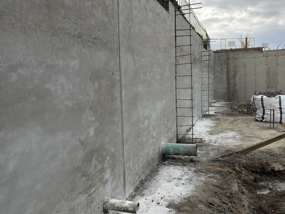 Finished shotcrete retaining wall with a clean, even face on a shored excavation, Regina, SK
