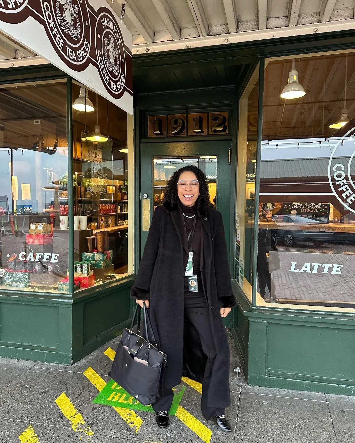 Shai Littlejohn standing outside of the original Starbucks in Seattle.