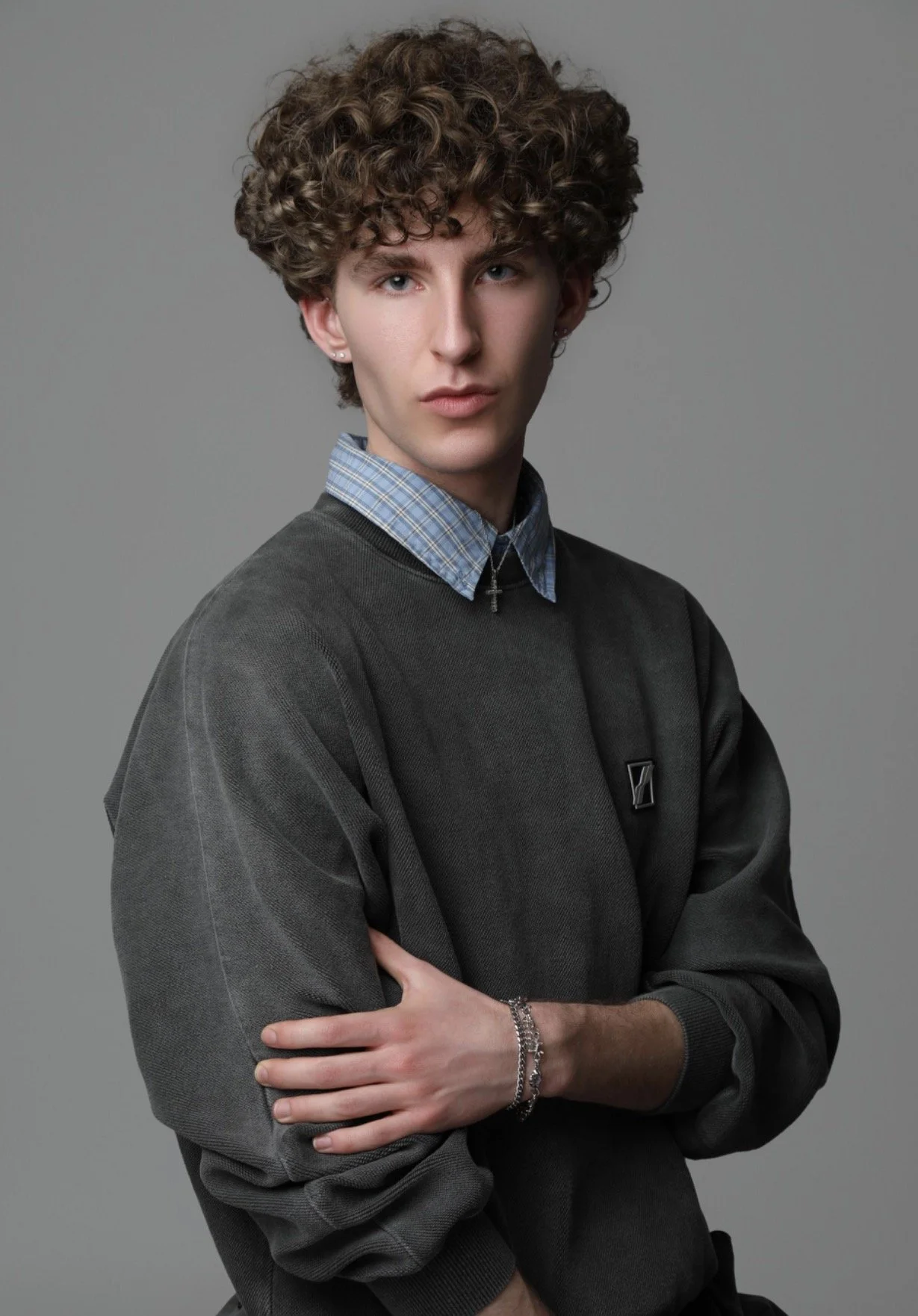  Andrea, male model represented by Noirvelle Models, photographed in a studio portrait wearing layered fashion and jewelry.