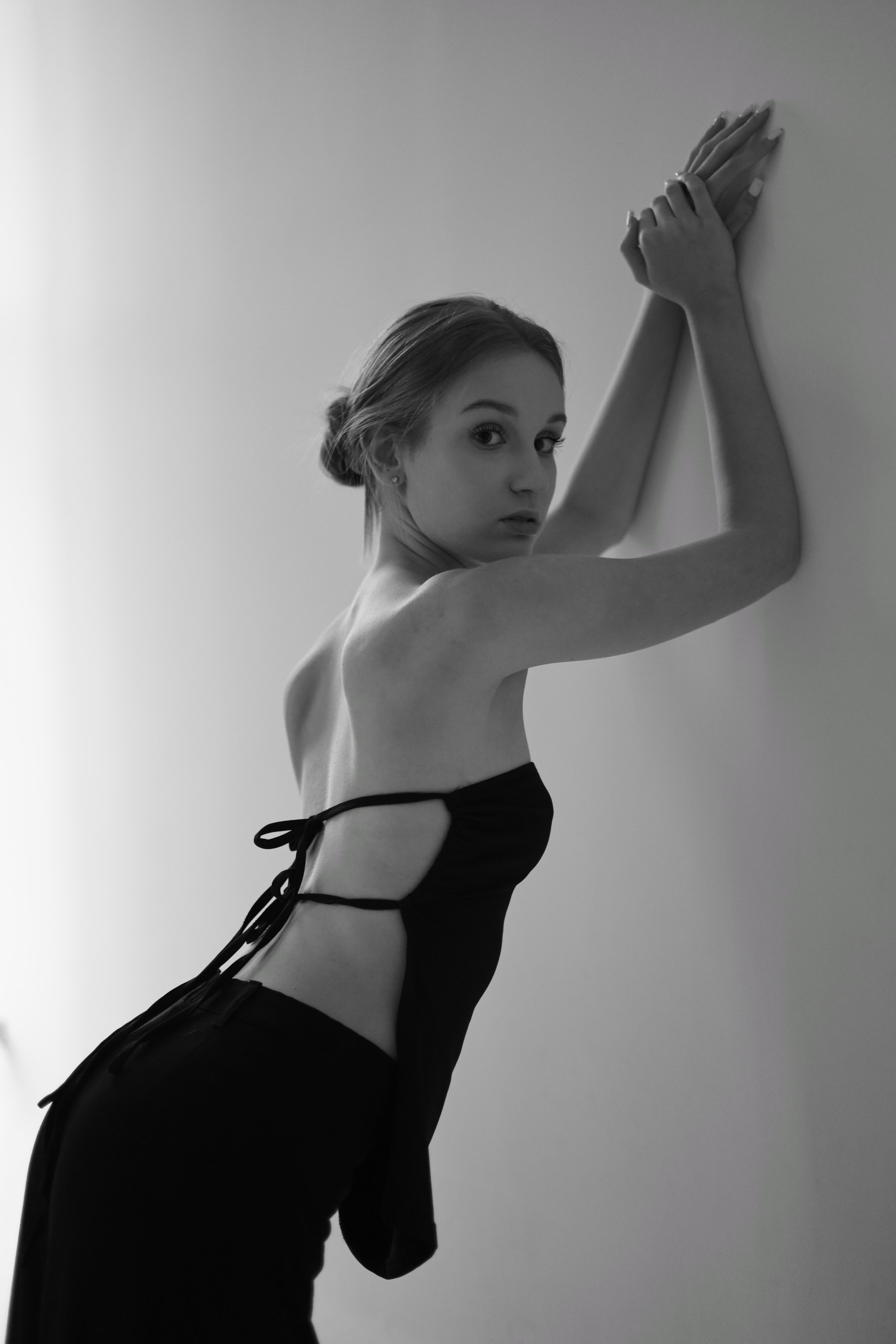 Victoria, female model represented by Noirvelle Models, posing in a black top during a black and white fashion photoshoot.
