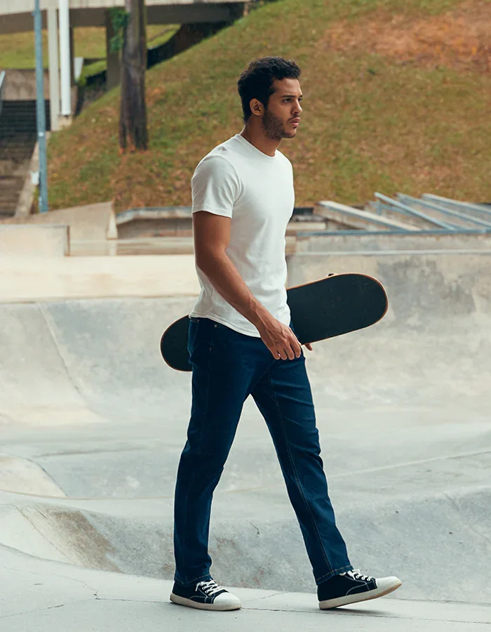 Bashir, male model represented by Noirvelle Models, holding a skateboard during an outdoor lifestyle photoshoot.
