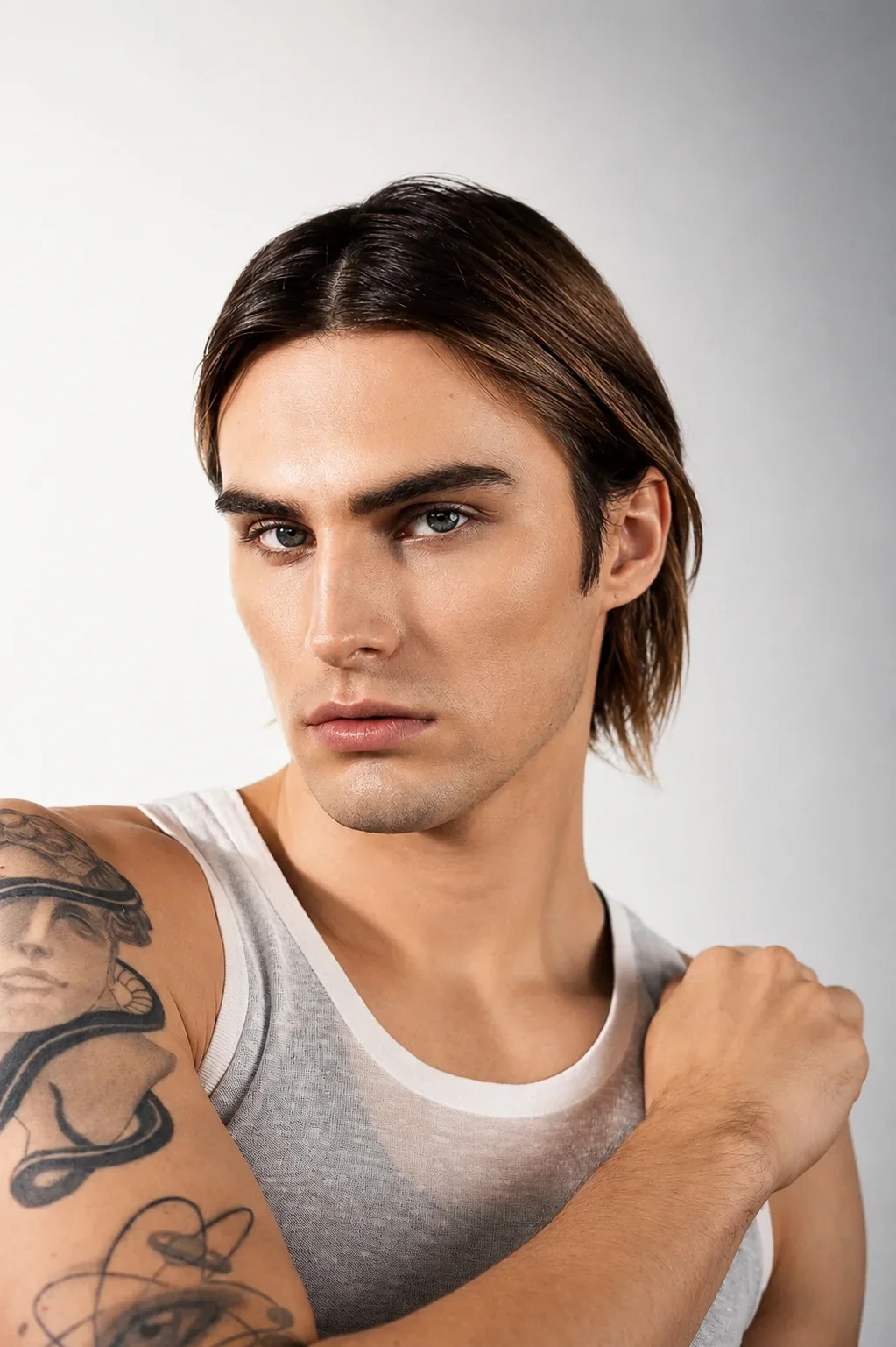 Konstantin Churakov — male fashion model represented by Noirvelle Models, featured in a close-up editorial portrait wearing a white sleeveless top.

