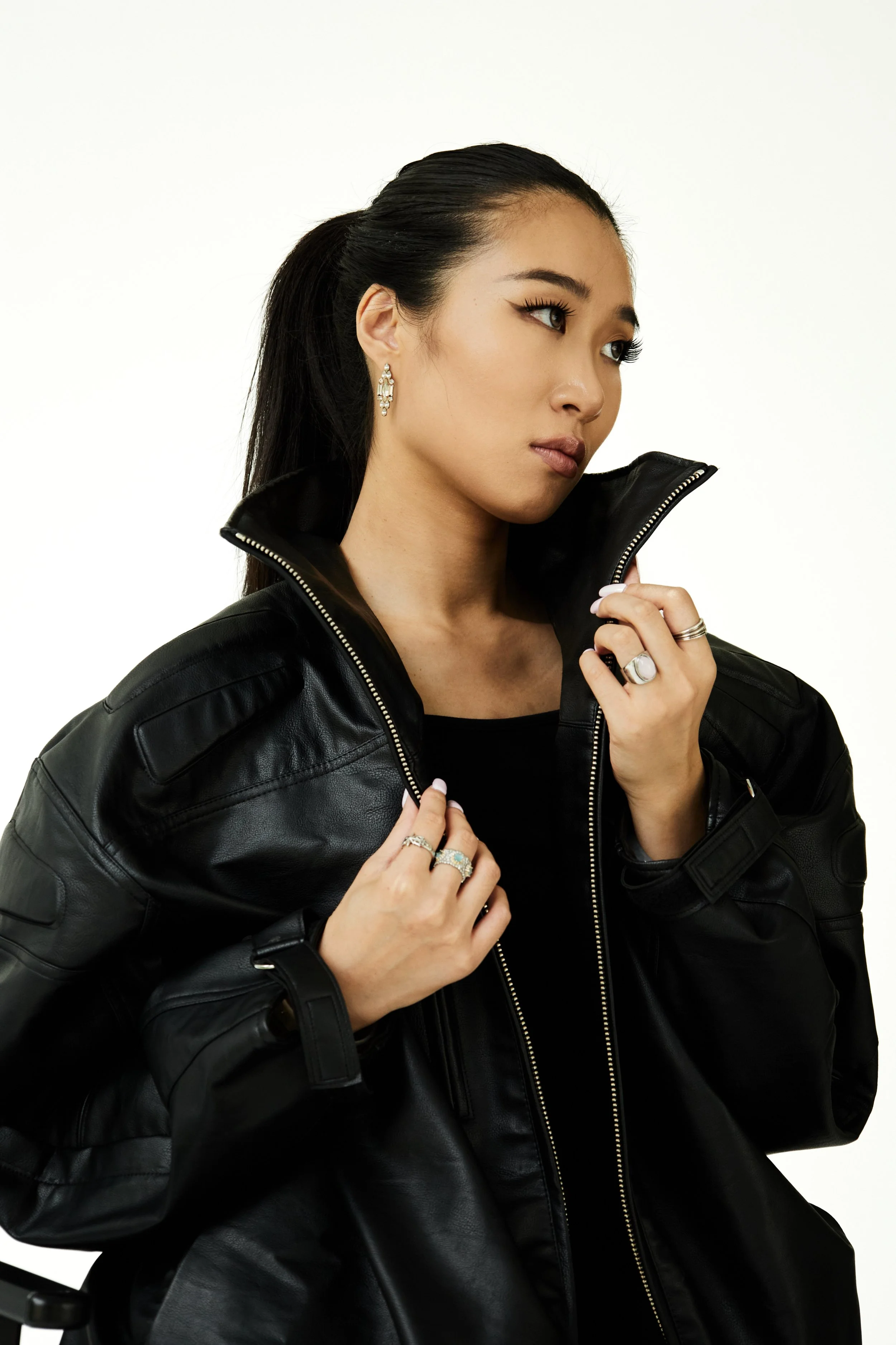 Joline, female fashion model represented by Noirvelle Models, wearing a black leather jacket in a studio fashion portrait.

