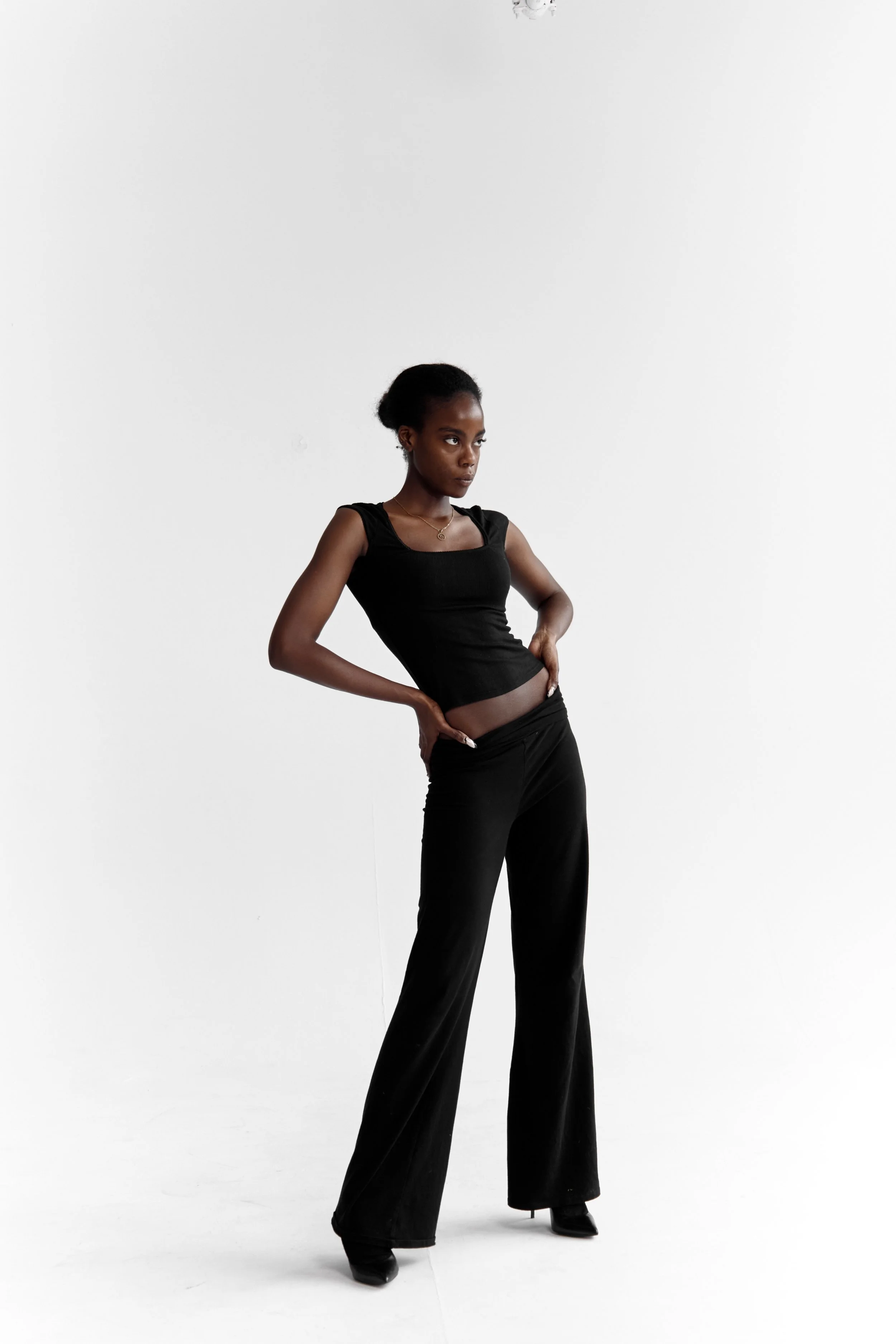 Daisy — female fashion model represented by Noirvelle Models, photographed in a full-length all-black editorial look against a white background.