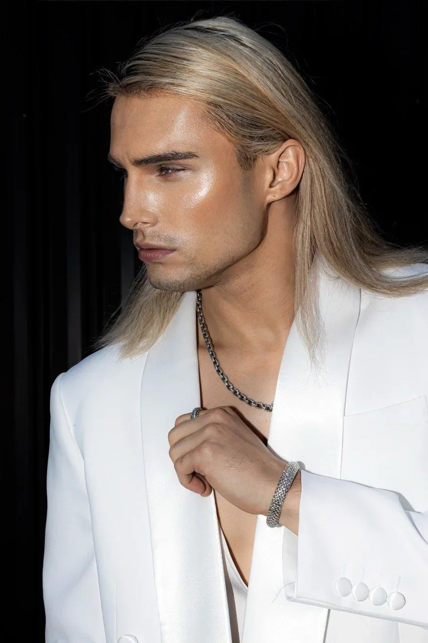Konstantin Churakov — male fashion model represented by Noirvelle Models, wearing a white suit in a fashion editorial portrait.
