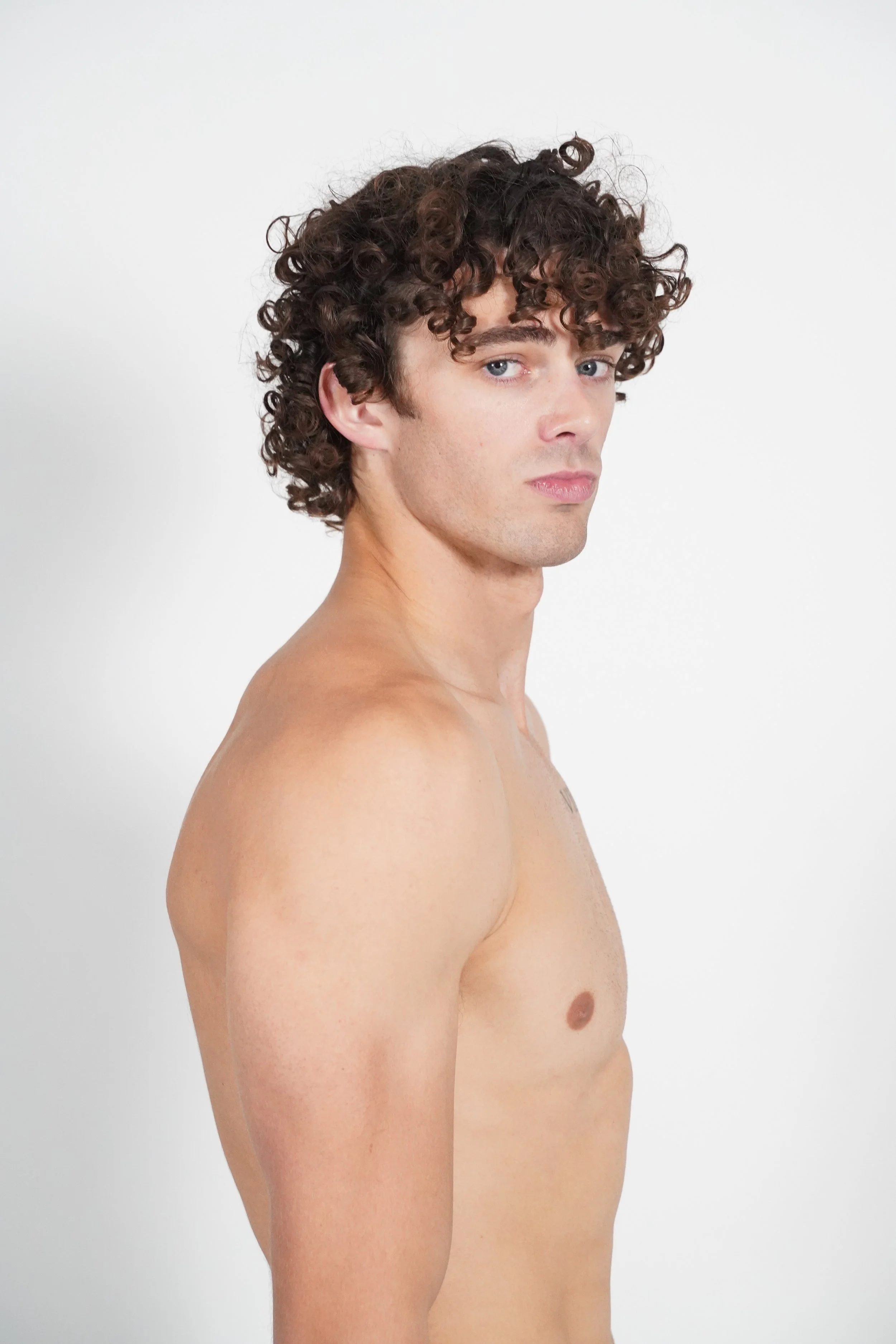 Maverick, male fashion model represented by Noirvelle Models, posing shirtless against a white studio background.
