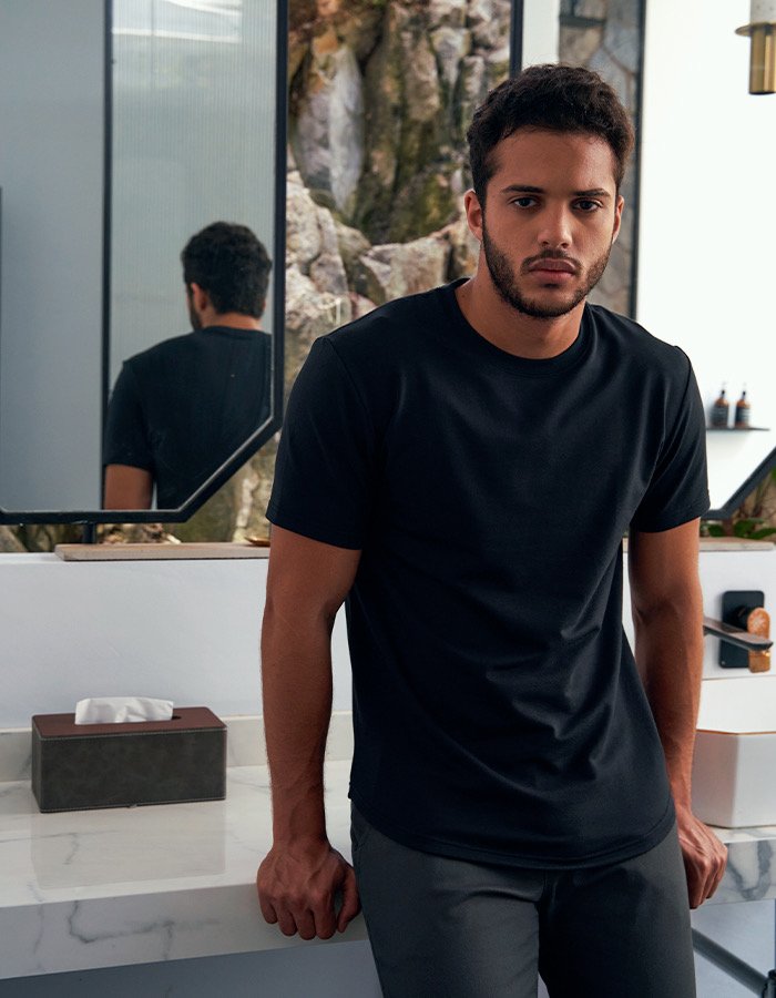 Bashir, male fashion model represented by Noirvelle Models, wearing a black T-shirt in a casual lifestyle portrait.

