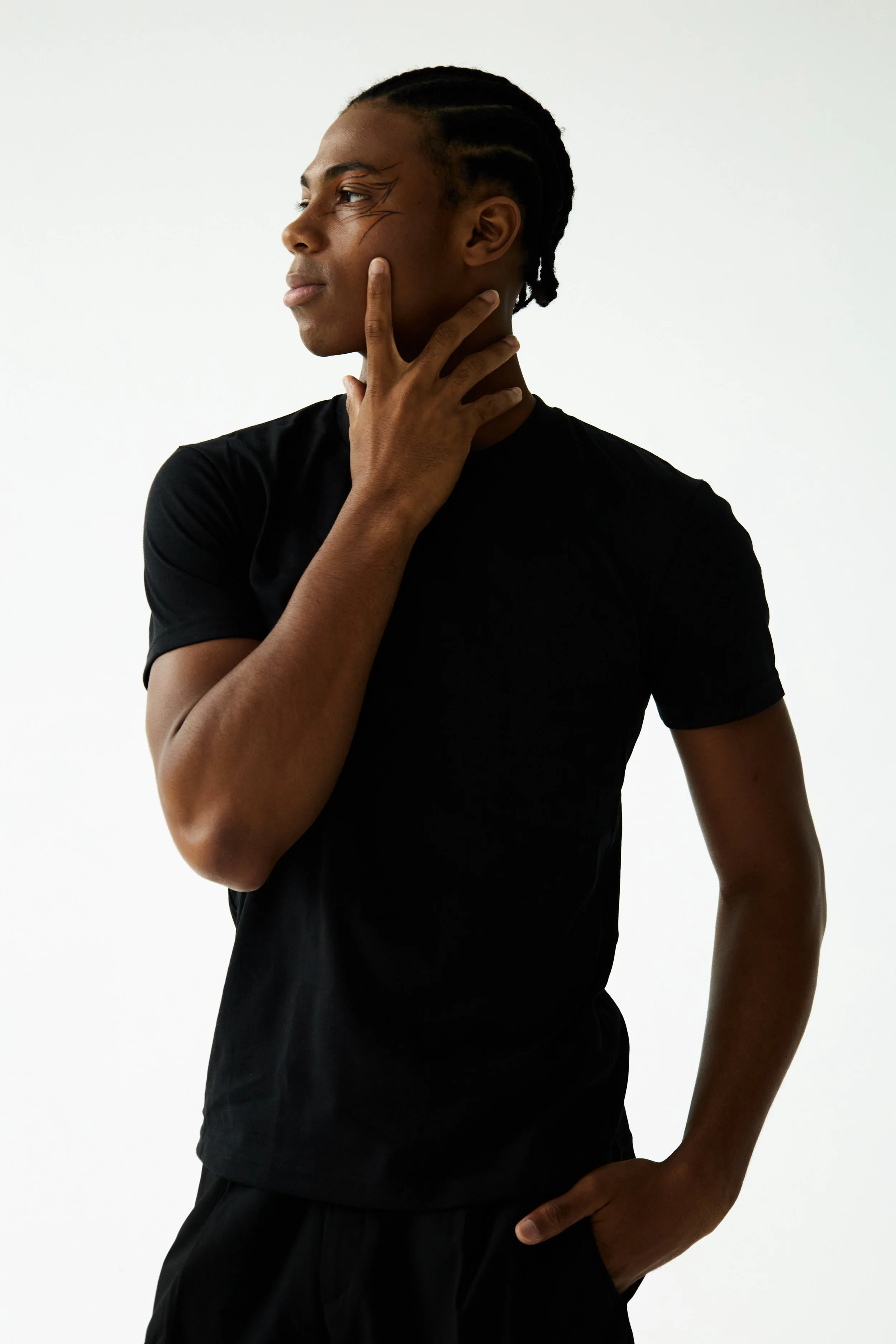 Jahvante, male fashion model represented by Noirvelle Models, posing in a black T-shirt against a white studio background.
