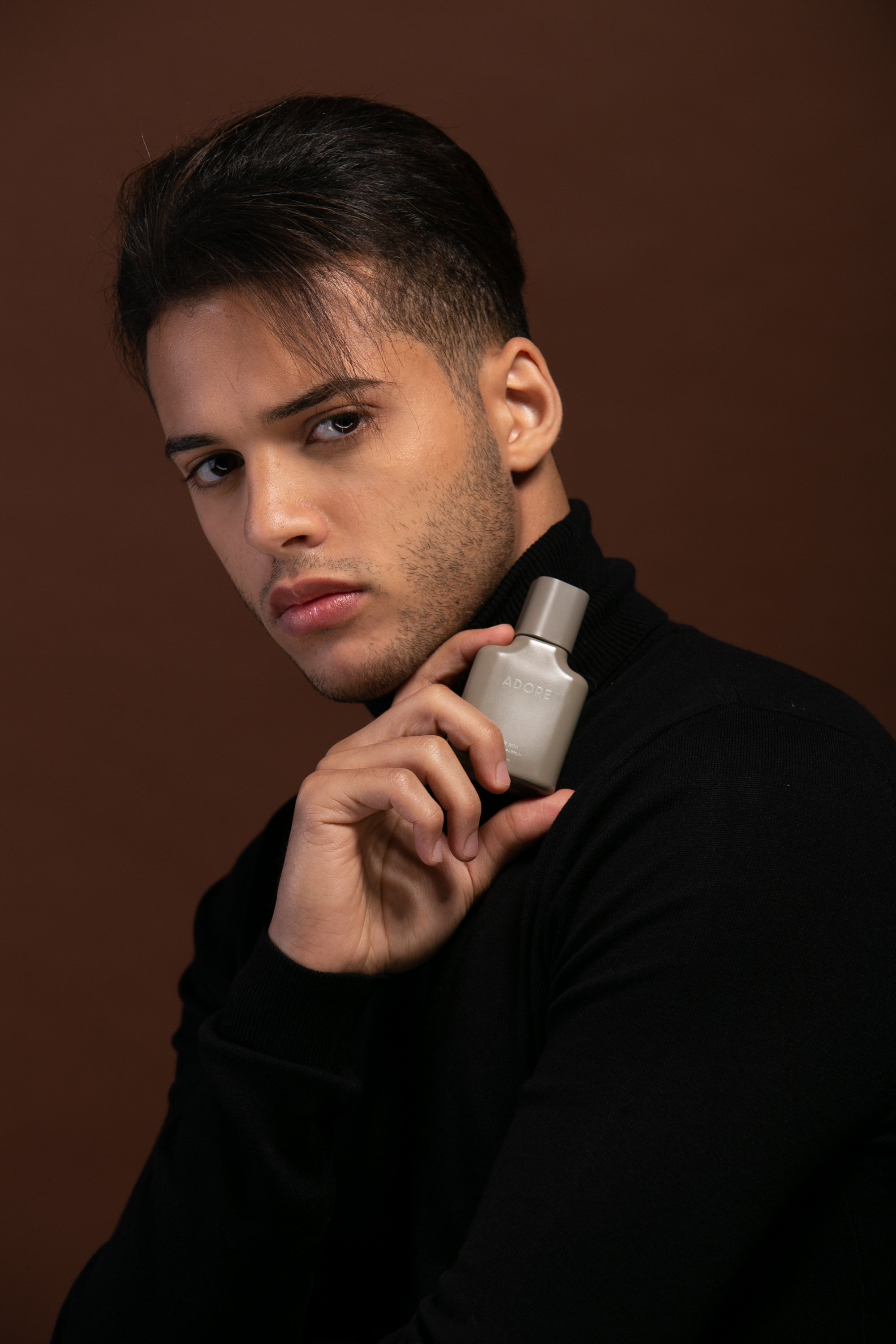 Bashir, male model represented by Noirvelle Models, posing with a grooming product during a commercial beauty photoshoot.
