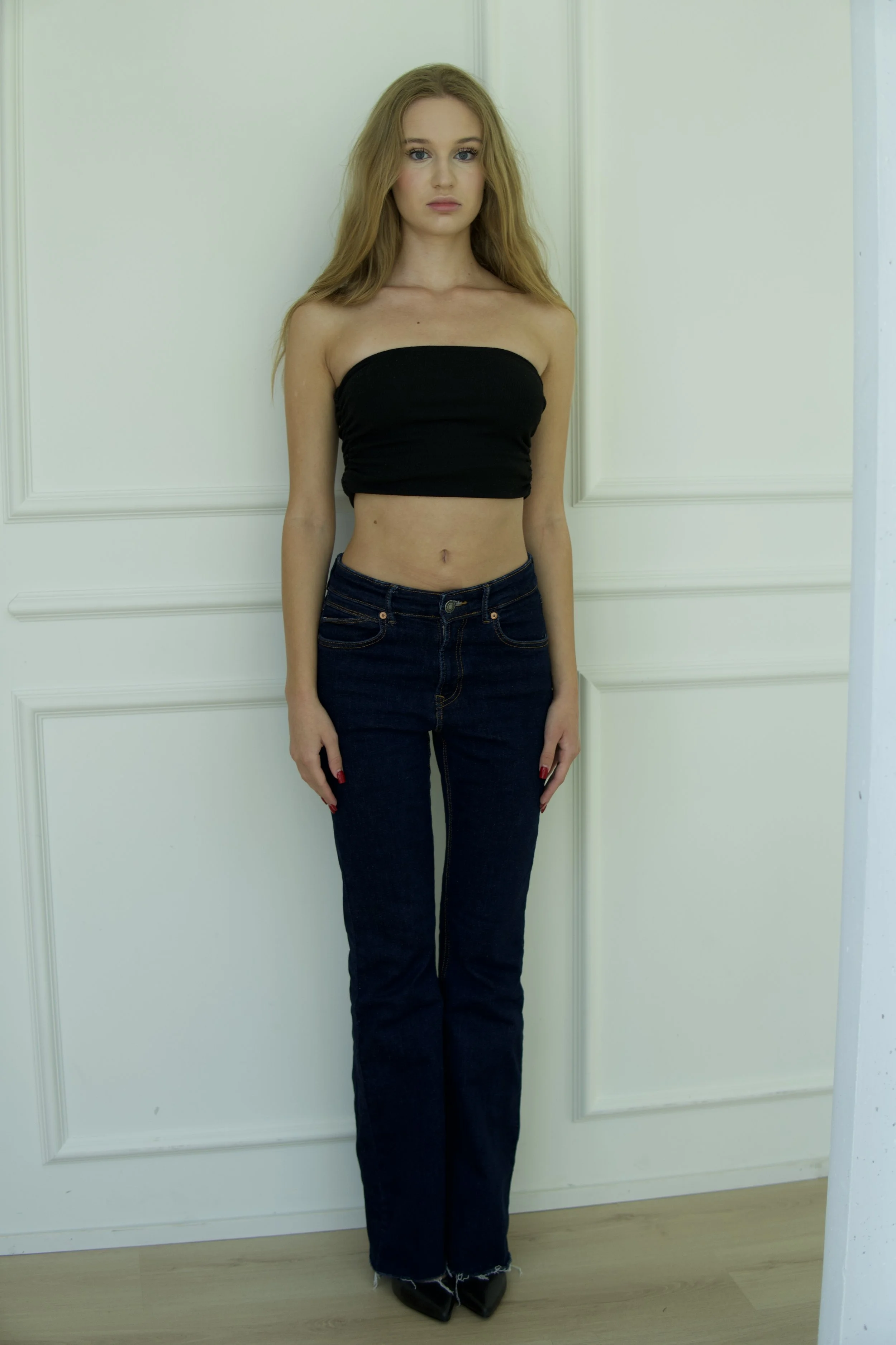 Victoria, female model represented by Noirvelle Models, full-length model test in a black top, jeans and heels.
