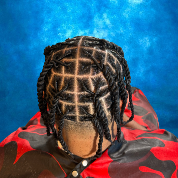 Top view of a person with styled dreadlocks and wearing a red and black camouflage jacket, against a blue background.