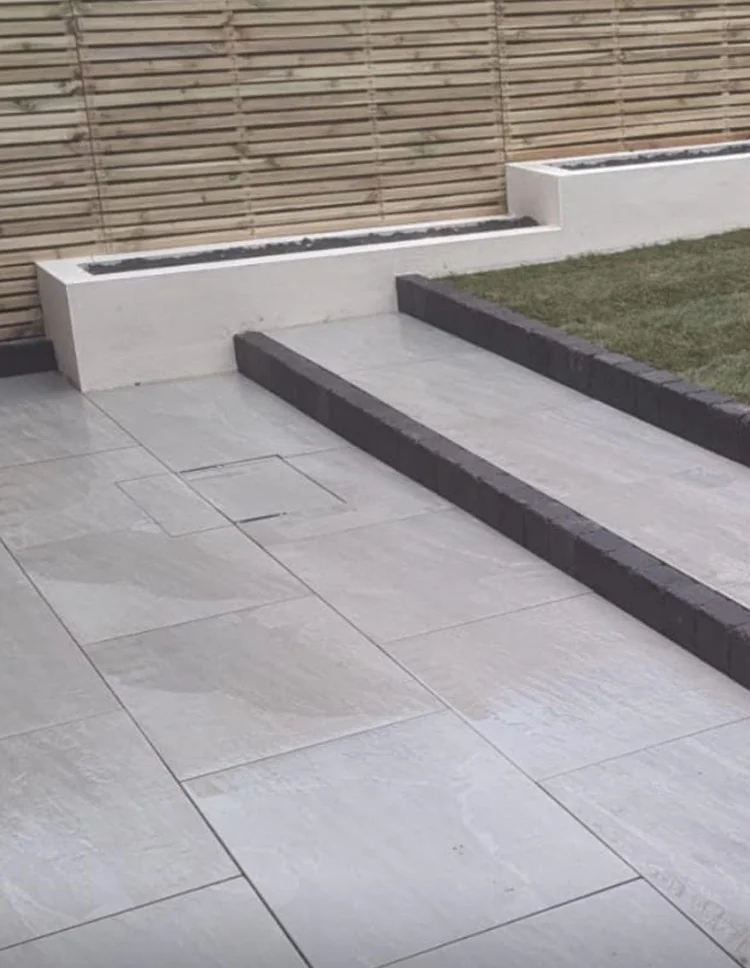 Tiered grey porcelain patio with rendered planters