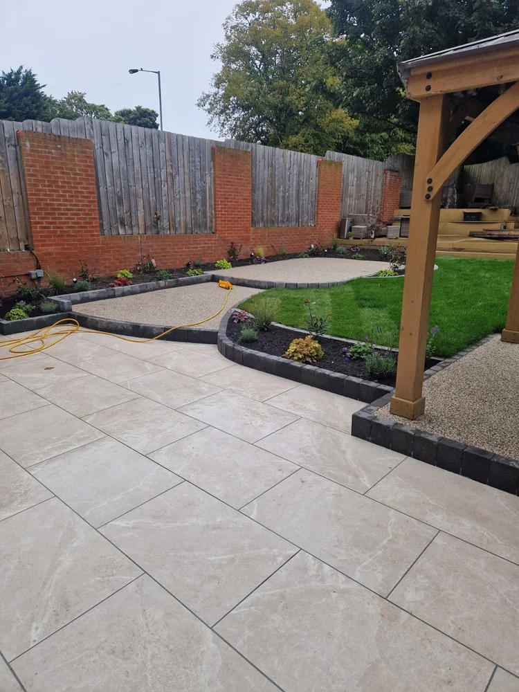 Porcelain patio curving round a new lawn and gazebo
