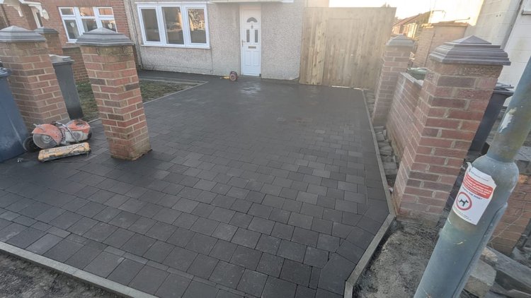 Charcoal block paving between brick pillars