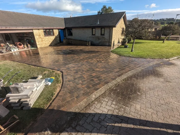 Large brindle block-paved driveway at a rural bungalow