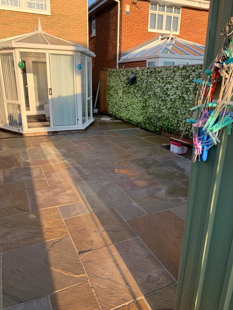 Sandstone patio beside a conservatory
