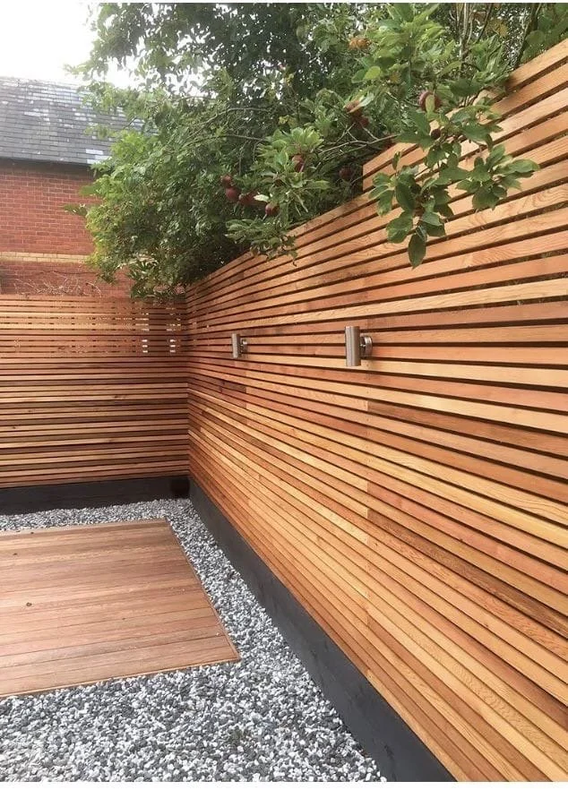 Cedar slatted screening with gravel and a small deck