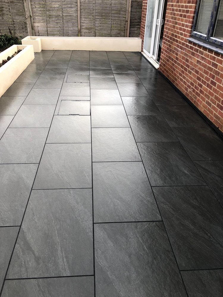Dark grey porcelain patio against the house