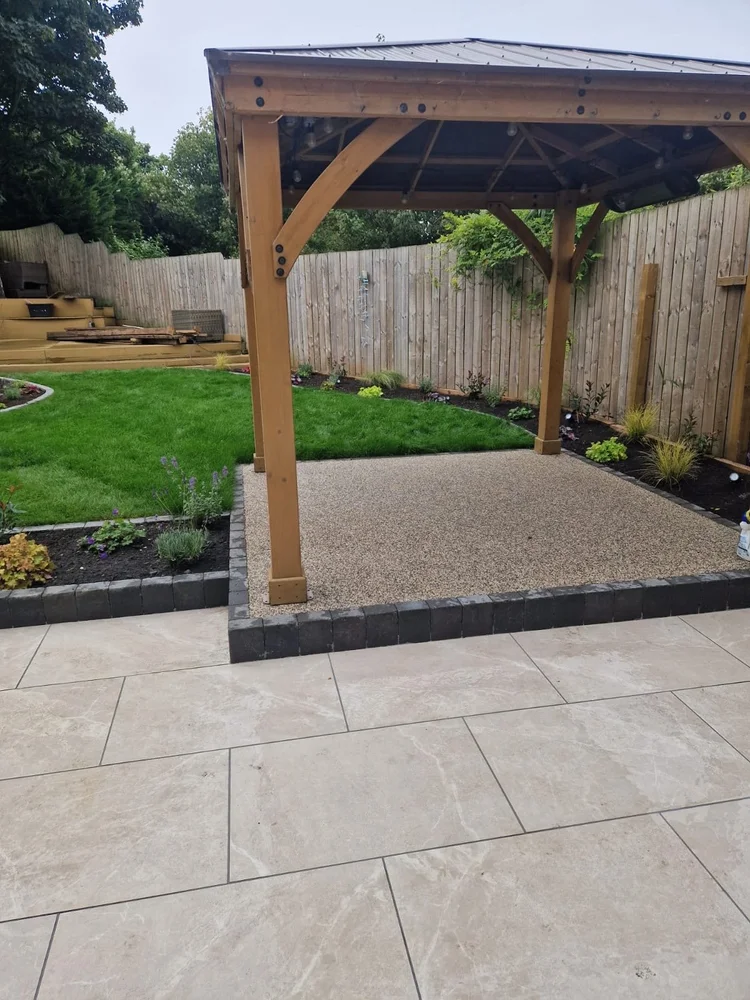 Timber gazebo on resin beside a porcelain patio