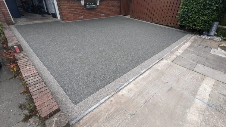 Grey resin driveway with brick edging