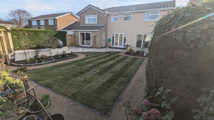 Striped new lawn in a family garden